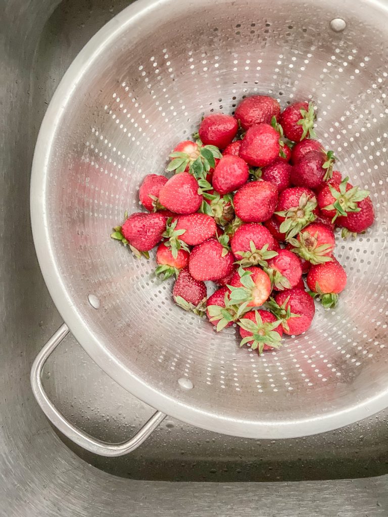 strawberries in a metal colander