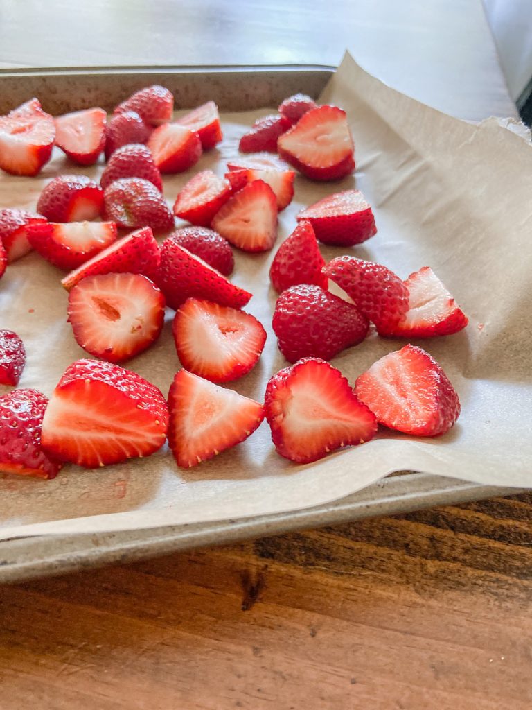 fresh sliced strawberries on a cookie sheet