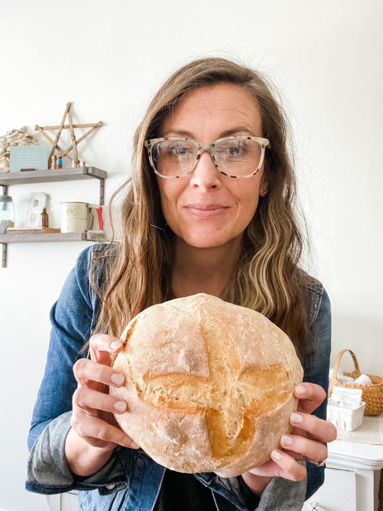 woman holding sourdough loaf in her hands