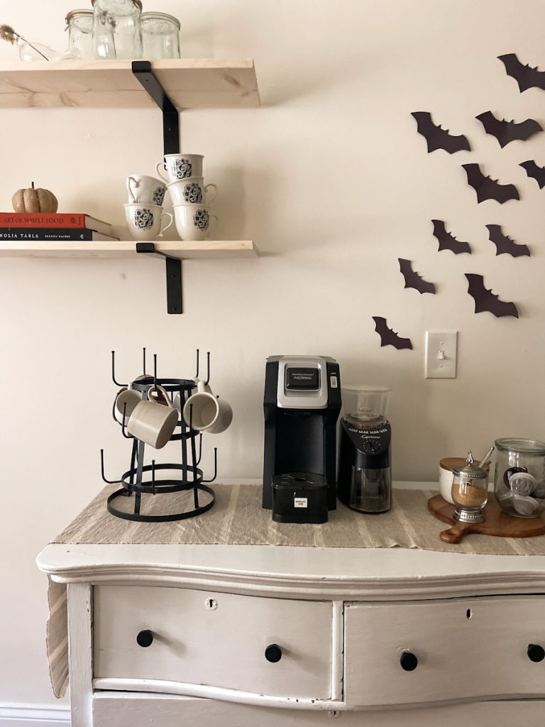 coffee bar setup with black construction paper bats on the wall behind for halloween decoration