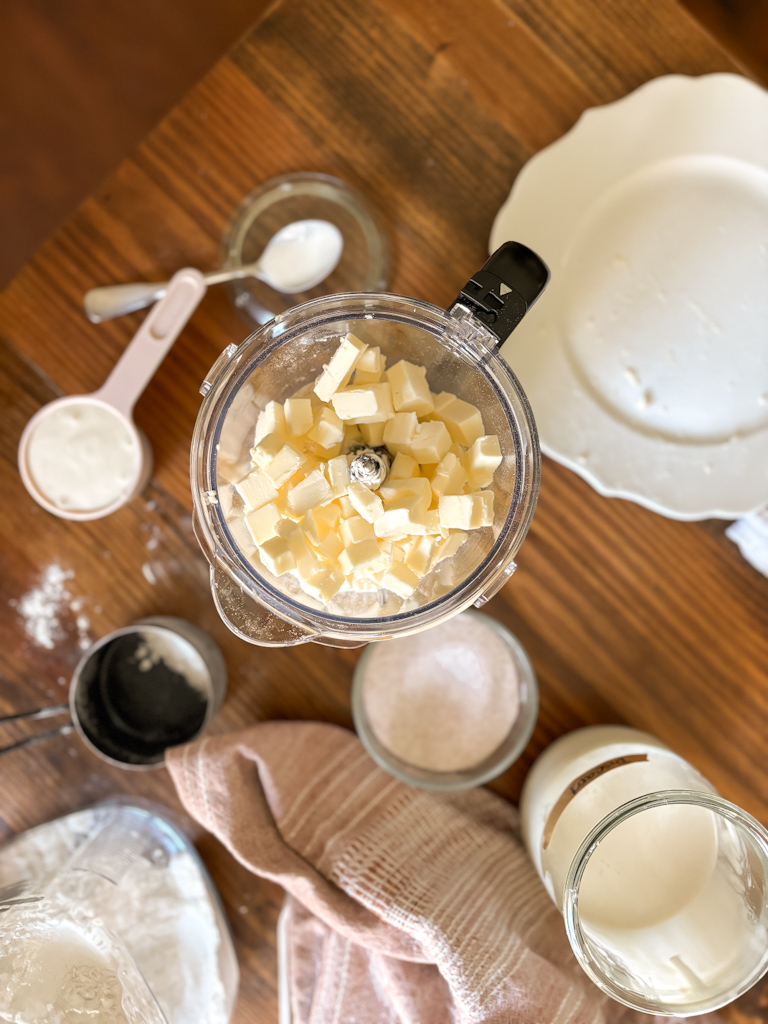 cubed butter inside food processor on a table top