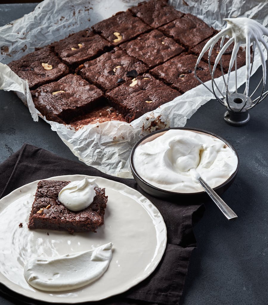 Mouth-watering brownie served with whipped cream, perfect for dessert lovers.