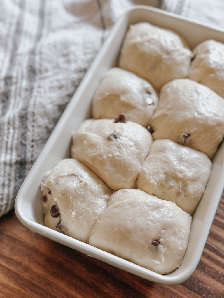 chocolate chip brioche dough in a cream loaf pan on a table