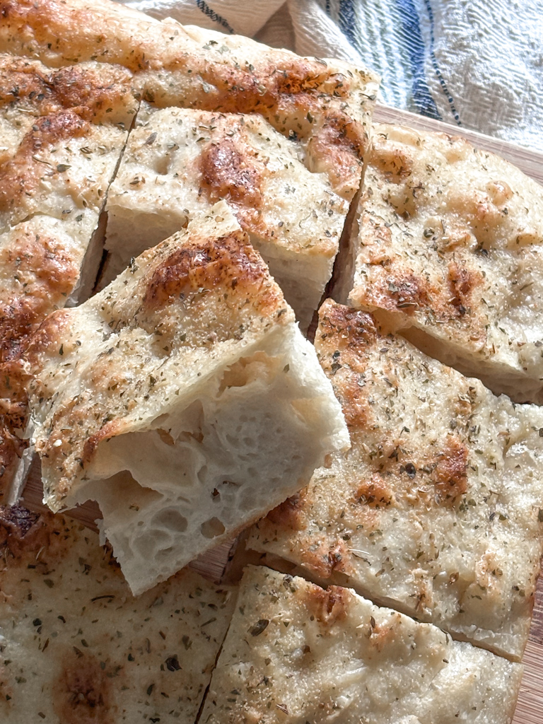 no knead focaccia bread sliced in a pan