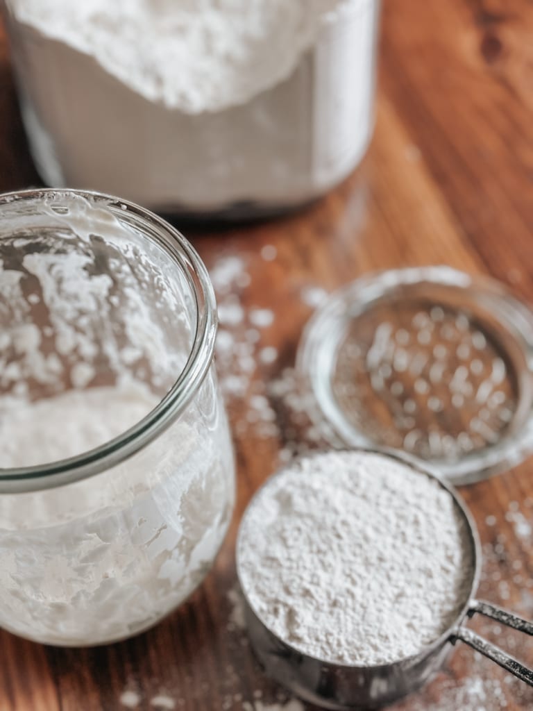 sourdough discard in a jar beside a measuring cup of flour