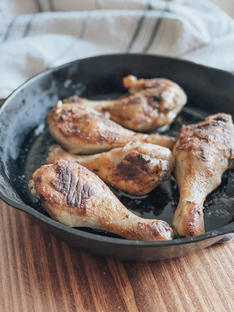 chicken drumstics in a cast iron skillet