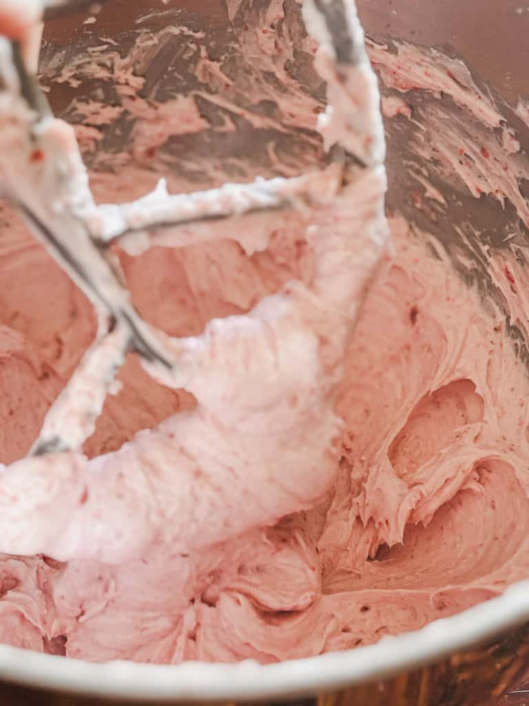 bowl of strawberry frosting with whisk