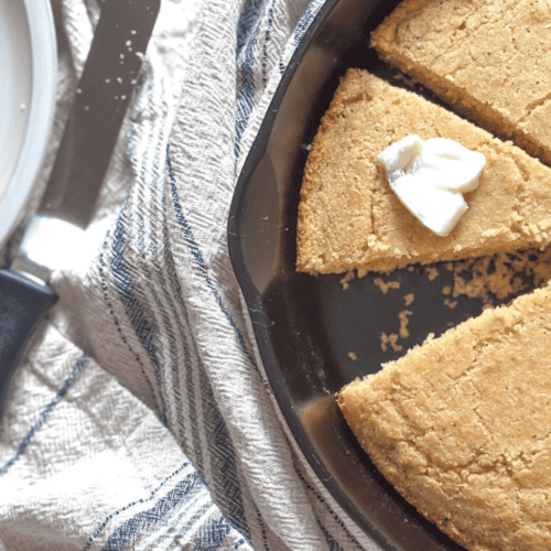 southern style cornbread in a cast iron skillet with a dollop of butter