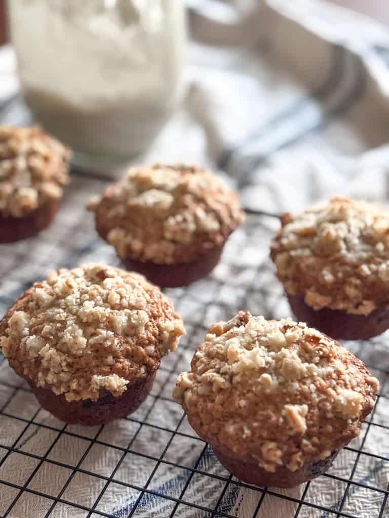 sourdough banana muffins on a wire rack with a jar of sourdough in the back