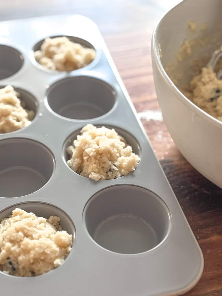 muffin tin with sourdough blueberry muffin batter
