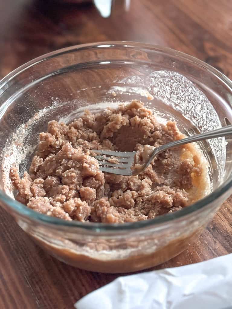 glass bowl of crumb topping for sourdough discard coffee cake with a fork