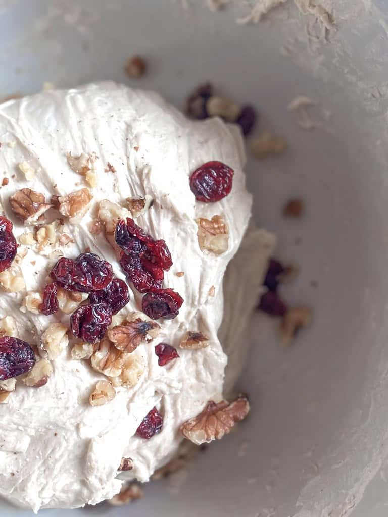 close up of dough with cranberries and walnuts mixed in