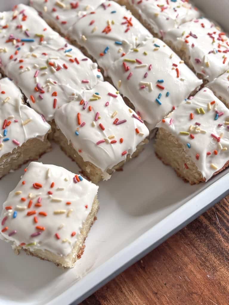 top view of a birthday sheet cake cut into squares.