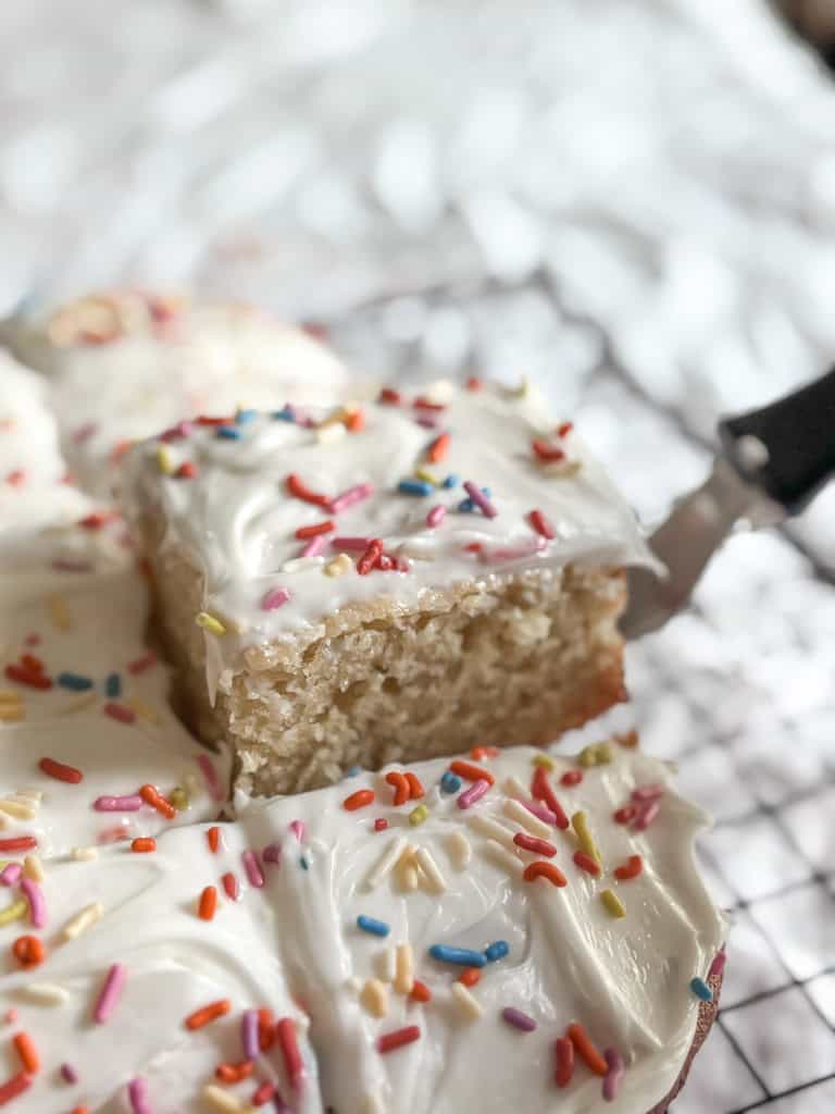 close up of a piece of birthday cake being removed from the whole cake