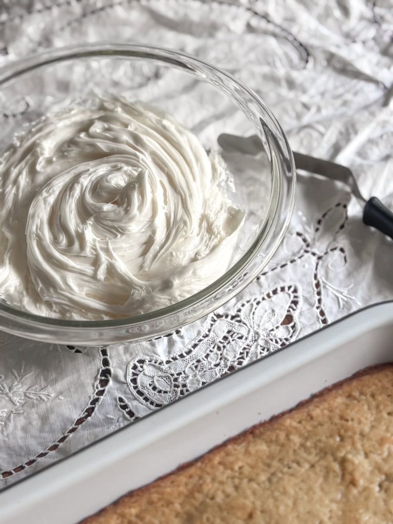 clear bowl of frosting on a white table cloth
