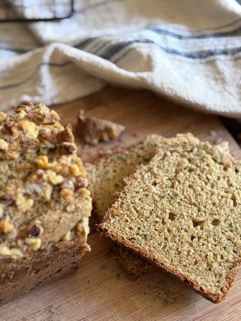 sourdough zucchini bread sliced and on a wooden cutting board