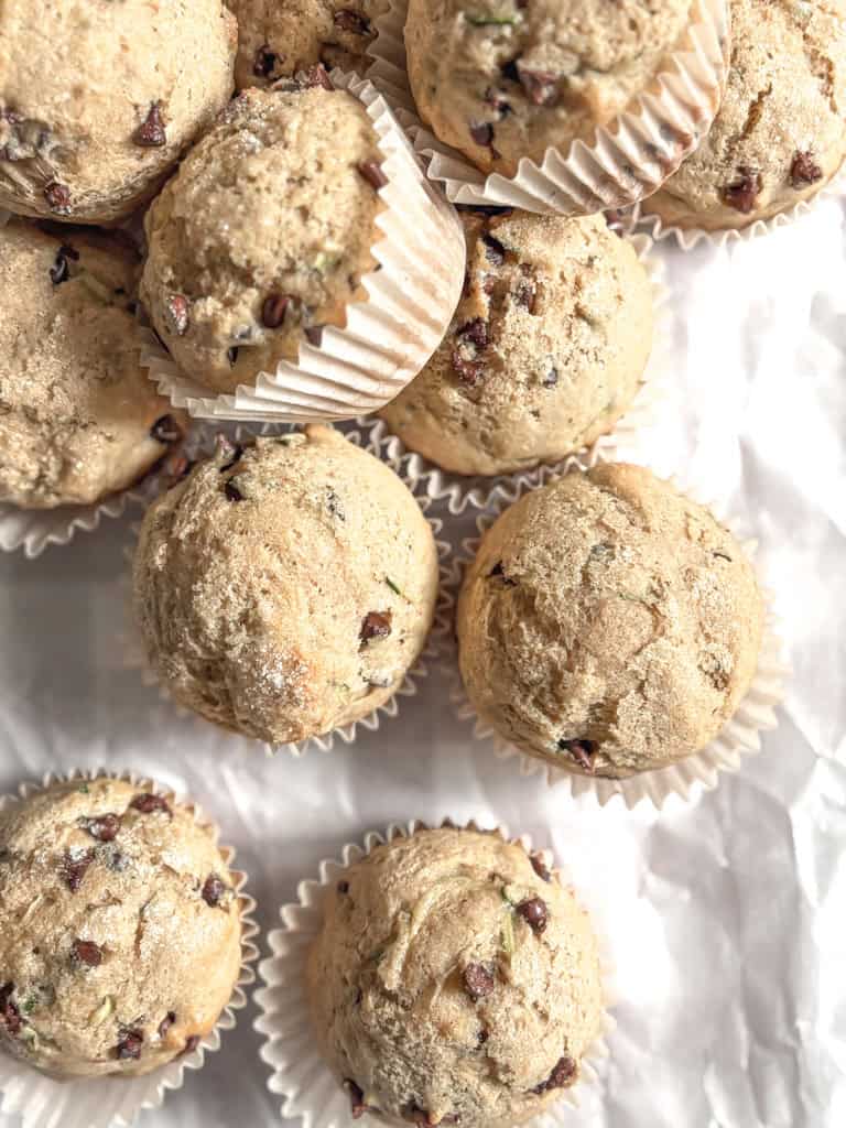 zucchini chocolate chip muffins on a piece of parchment paper