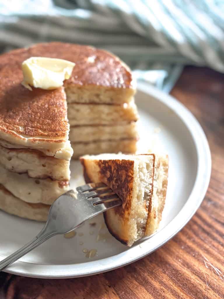 stack of pancakes with a bite on a fork