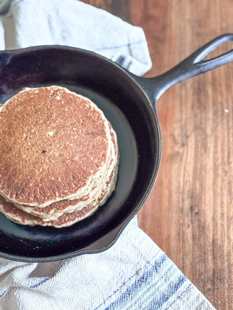 cast iron skillet stacked with fresh milled flour pancakes
