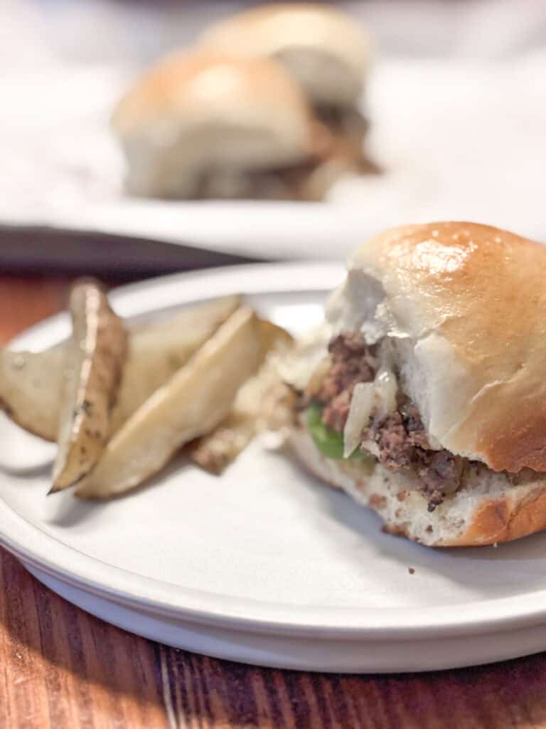 plate with homemade fries and a burger on a homemade dinner rolls