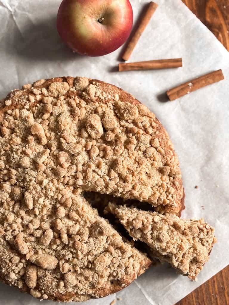 top view of sourdough apple cake next to apple and cinnamon sticks